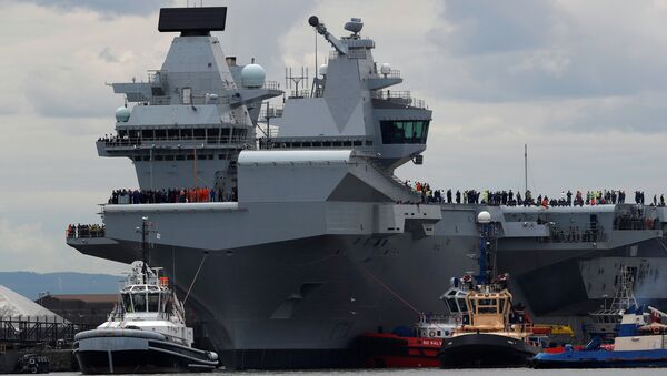 The British aircraft carrier HMS Queen Elizabeth is pulled from its berth by tugs before its maiden voyage, in Rosyth, Scotland, Britain June 26, 2017. - Sputnik Việt Nam