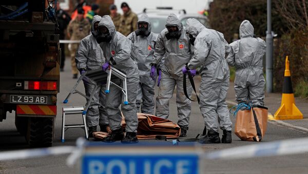 British Military personnel wearing protective coveralls work to remove a vehicle connected to the March 4 nerve agent attack in Salisbury, from a residential street in Gillingham, southeast England on March 14, 2018 - Sputnik Việt Nam