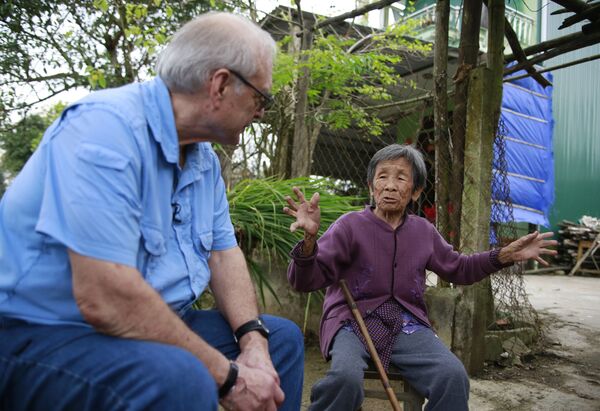 Nhiếp ảnh gia  Mỹ Ron Haeberle, người đã chụp ảnh sự kiện thảm sát hàng loạt ở Sơn Mỹ 50 năm trước, nói chuyện với cư dân địa địa phương Đỗ Thị Chi, sống sót sau vụ thảm sát - Sputnik Việt Nam
