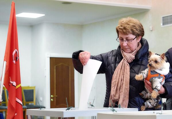 Một người phụ nữ với chú chó bỏ lá phiếu của mình trong cuộc bầu cử tổng thống ở St. Petersburg - Sputnik Việt Nam