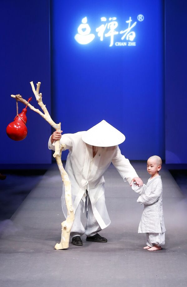 Hai người mẫu nam và trẻ em tại buổi trình diễn của Chan Zhe trong khuôn khổ Tuần lễ Thời trang Trung Quốc ở Bắc Kinh - Sputnik Việt Nam