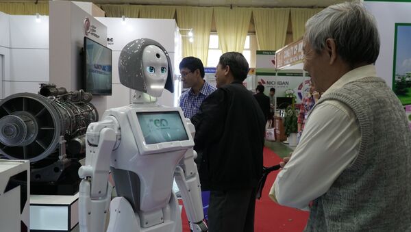 Khách thăm Triển lãm “Vietnam Expo 2018” nghiên cứu sản phẩm mới nhất – cô gái robot Kiki – của công ty điện tử Nga chuyên về robot điện tử Alfa Robotics - Sputnik Việt Nam