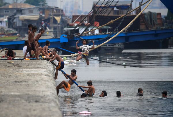 Trẻ em tắm trong vùng nước bị ô nhiễm vịnh Manila trong thời gian nắng đỉnh điểm ở Philippines - Sputnik Việt Nam
