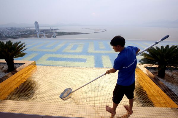 Nhân viên vệ sinh cạnh hồ bơi tại khách sạn Golden Bay Danang  ở Việt Nam - Sputnik Việt Nam