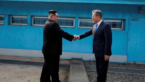 Лидеры Северной и Южной Корей Ким Чен Ын и Мун Чжэ Ин пожимают друг другу руки во время встречи в деревне Пханмунджом в демилитаризованной зоне, разделяющей две Кореи - Sputnik Việt Nam
