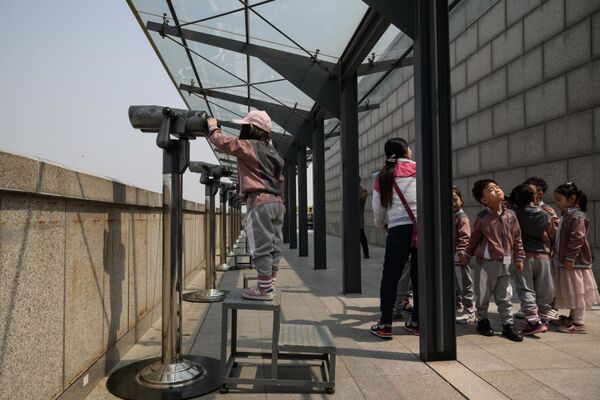 Các em học sinh đang dùng ống nhòm quan sát trên sân khu phi quân sự ở làng Panmunjom - Sputnik Việt Nam