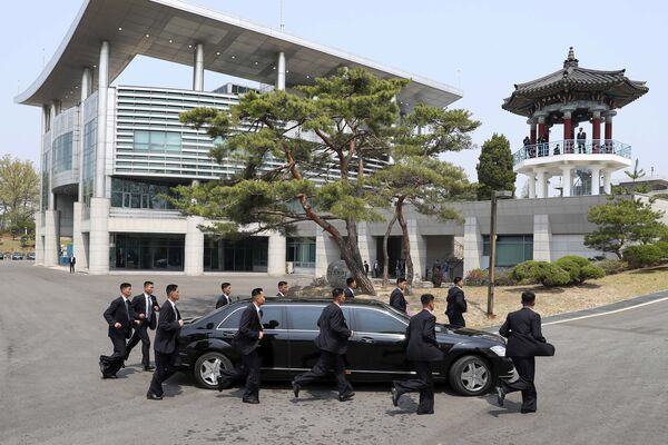 Các nhân viên an ninh của lãnh tụ Kim Jong-un hộ tống xe của ông. - Sputnik Việt Nam