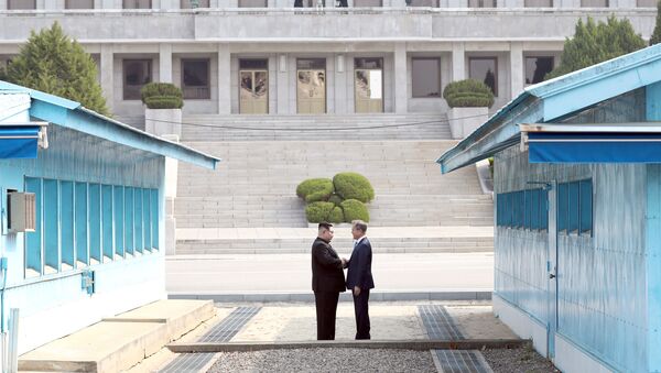 Lãnh tụ Nam-Bắc Triều Tiên Moon Jae-in và Kim Jong-un bắt tay nhau trong cuộc gặp gỡ tại làng Panmunjom, thuộc khu phi quân sự phân chia hai miền Bắc-Nam Triều Tiên. - Sputnik Việt Nam