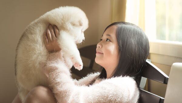 Cô bé châu Á với một chú cún con - Sputnik Việt Nam