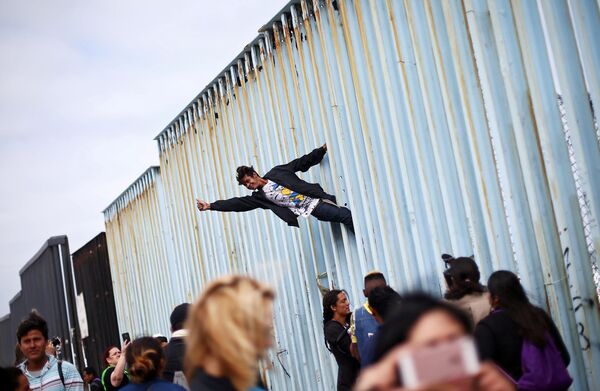Thành viên tham gia cuộc biểu tình của những người di cư trên hàng rào ngăn cách Mexico và Mỹ ở đường biên giới - Sputnik Việt Nam