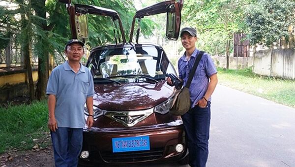 Ông Trần Văn Tâm (trái) bên mẫu ôtô điện của mình. - Sputnik Việt Nam