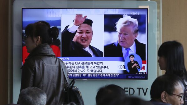 People pass by a TV screen showing file footages of U.S. President Donald Trump, right, and North Korean leader Kim Jong Un during a news program at the Seoul Railway Station in Seoul, South Korea, Monday, April 9, 2018 - Sputnik Việt Nam