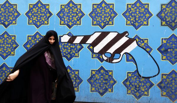 Người phụ nữ Iran trên nền cảnh graffiti tại tòa nhà cũ của Đại sứ quán Mỹ ở Tehran - Sputnik Việt Nam