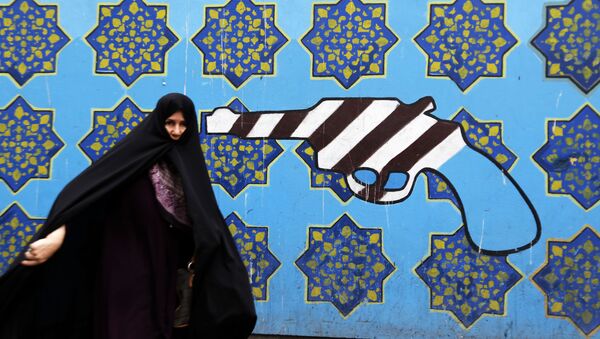 Người phụ nữ Iran trên nền cảnh graffiti tại tòa nhà cũ của Đại sứ quán Mỹ ở Tehran - Sputnik Việt Nam
