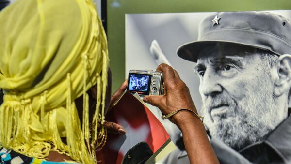 Một phụ nữ chụp bức ảnh chân dung cựu Chủ tịch Cuba Fidel Castro - Sputnik Việt Nam