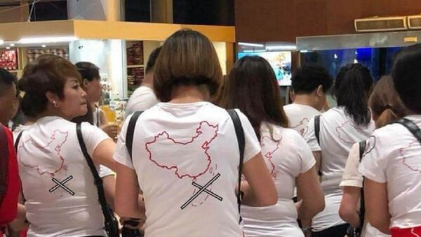 Nhóm khách Trung Quốc mặc áo in hình đường lưỡi bò nhập cảnh sân bay Cam Ranh. - Sputnik Việt Nam