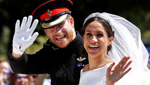Britain’s Prince Harry and his wife Meghan wave as they ride a horse-drawn carriage after their wedding ceremony at St George’s Chapel in Windsor Castle in Windsor, Britain, May 19, 2018 - Sputnik Việt Nam