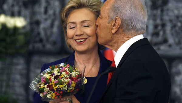 Tổng thống Israel Shimon Peres ôm hôn Ngoại trưởng Mỹ Hillary Clinton, tặng bà bó hoa sau cuộc họp báo chung ở Jerusalem, năm 2009 - Sputnik Việt Nam