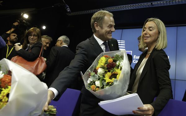 Thủ tướng Ba Lan Donald Tusk và Bộ trưởng Bộ Ngoại giao Ý Federica Mogherini cùng những bó hoa sau khi tiếp xúc với các phương tiện truyền thông trong hội nghị thượng đỉnh EU tại Brussels, năm 2014 - Sputnik Việt Nam