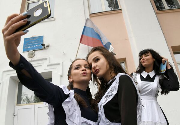 Học sinh tốt nghiệp chụp ảnh selfie tại cổng trường ở Chita, Nga - Sputnik Việt Nam