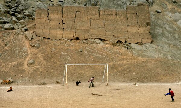 Các em trai chơi bóng đá trong khu vực khai quật khảo cổ ở Puruchuko (Lima) - Sputnik Việt Nam