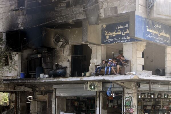 Người dân địa phương trên ban công một ngôi nhà bị phá hủy ở Aleppo (Syria) - Sputnik Việt Nam