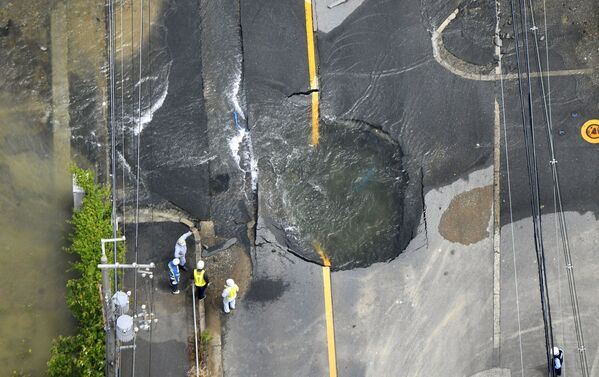 Hố hình thành sau trận động đất và chứa đầy nước nằm giữa đường ở quận Osaka, Nhật Bản - Sputnik Việt Nam