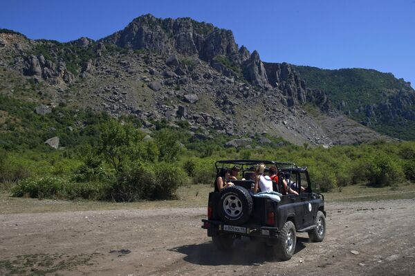 Du khách đi tham quan trên xe jeep trong vùng núi lân cận Demerdzhi ở Crưm - Sputnik Việt Nam