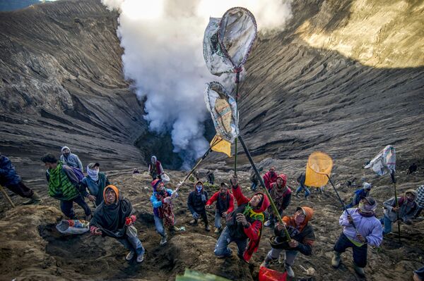 Mọi người đang chuẩn bị để đón nhận đồ tế, do các thành viên của bộ tộc Tengger ném vào miệng núi lửa Bromo ở Indonesia, trong ngày lễ Hindu Yadnya Kasada - Sputnik Việt Nam