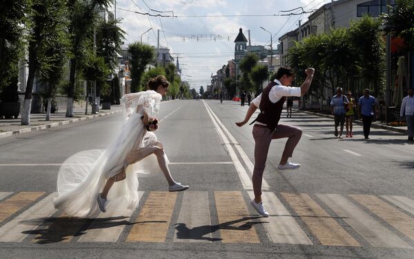 Cặp đôi mới cưới tạo dáng trước nhiếp ảnh gia trên lối qua đường ở Samara, Nga - Sputnik Việt Nam