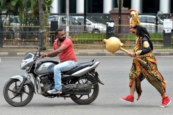 Nghệ sĩ trong vai vị thần chết Yama, đạo Hindu gần  người lái xe  trong sự kiện do cảnh sát Ấn Độ có tổ chức Tuần lễ An toàn trên đường, Bangalore - Sputnik Việt Nam