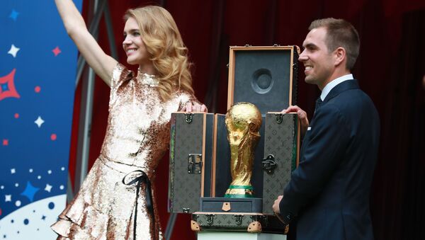 Sáng lập gia Quỹ “Trái tim để ngỏ” Natalya Vodyanova và cầu thủ bóng đá Philippe Lam rước chiếc Cup tại lễ bế mạc World Cup - Sputnik Việt Nam