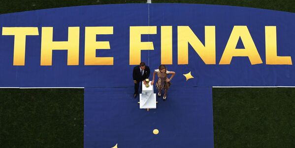 Sáng lập gia Quỹ “Trái tim để ngỏ” Natalya Vodyanova và cầu thủ bóng đá Philippe Lam rước chiếc Cup tại lễ bế mạc World Cup - Sputnik Việt Nam