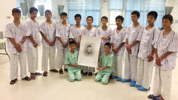 Các thiếu niên Thái Lan được cứu thoát với bức ảnh của Samarn Kunan đã hy sinh trong các hoạt động cứu hộ - Sputnik Việt Nam