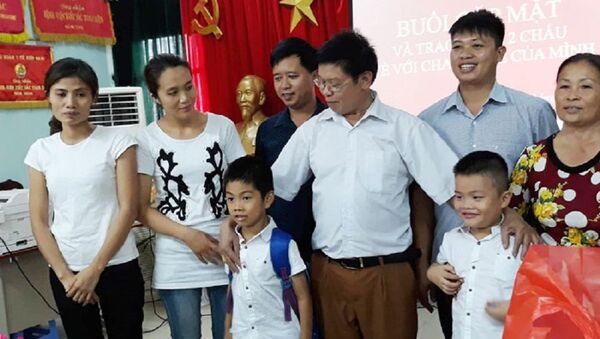 Hai gia đình và hai cháu bé tại buổi trao nhận con - Sputnik Việt Nam