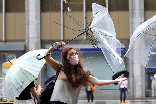 Cô gái với chiếc ô trong cơn gió mạnh ở Tokyo - Sputnik Việt Nam