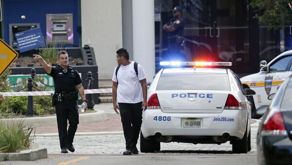 A police officer directs a pedestrian away from a blocked-off area near the scene of a mass shooting at Jacksonville Landing in Jacksonville, Fla., Sunday, Aug. 26, 2018. - Sputnik Việt Nam