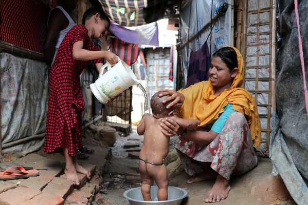 Người phụ nữ Rohingya tắm cho con trong trại tị nạn Kutupalong, Bangladesh - Sputnik Việt Nam