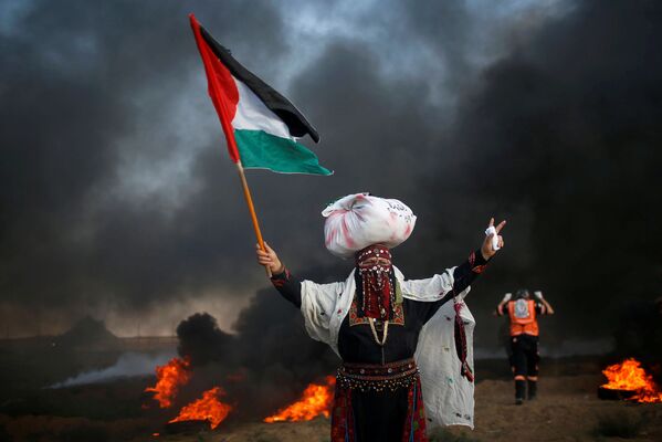 Một người phụ nữ với lá cờ Palestine trong một cuộc biểu tình chống lại việc Israel phong tỏa Dải Gaza - Sputnik Việt Nam