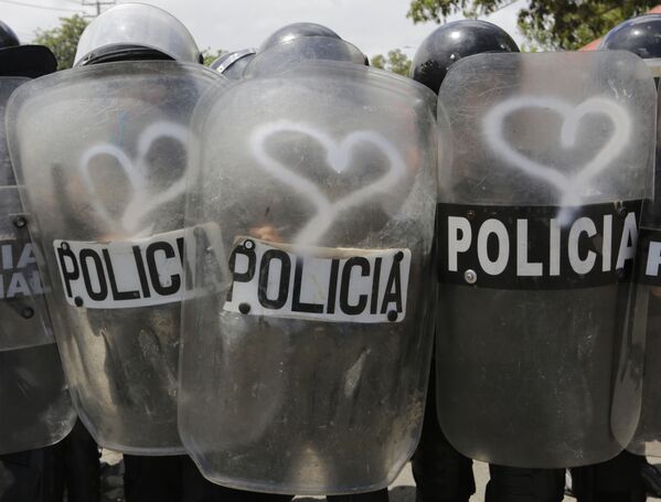 Cảnh sát đặc nhiệm với tấm lá chắn vẽ hình trái tim trong cuộc đụng độ với người biểu tình chống chính sách của Tổng thống Nicaragua Daniel Ortega ở Managua - Sputnik Việt Nam