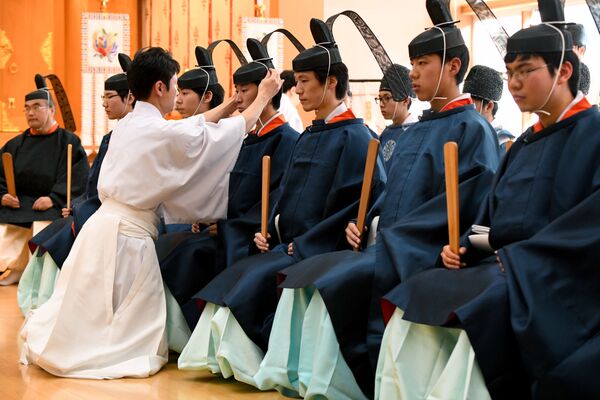 Giáo viên chỉnh lại chiếc mũ cho một người trẻ trong buổi lễ Shinto truyền thống tại Đại học Kokugakuin, Tokyo - Sputnik Việt Nam