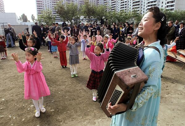 Trẻ em Bắc Triều Tiên nhảy múa và hát theo tiếng đàn đệm của giáo viên trong lúc chào mừng Ngoại trưởng Mỹ Madeleine Albright ở Bình Nhưỡng, năm 2000 - Sputnik Việt Nam