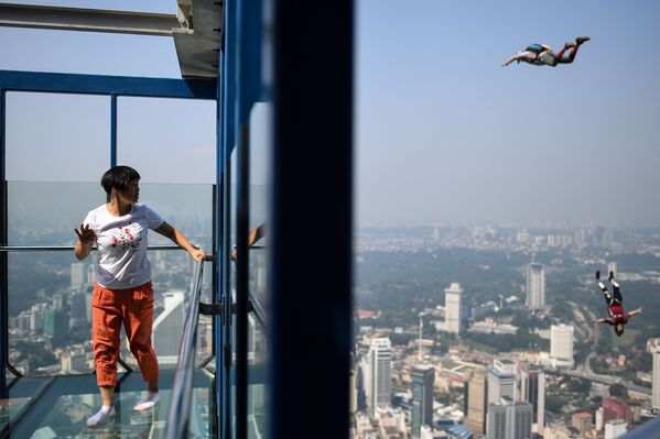 Du khách ngắm những người nhảy từ đài quan sát tháp truyền hình Menara ở Kuala Lumpur, Malaysia. - Sputnik Việt Nam