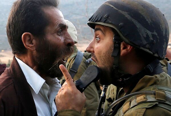 Người đàn ông Palestine tranh luận với một người lính Israel trong cuộc đụng độ ở Bờ Tây sông Jordan - Sputnik Việt Nam