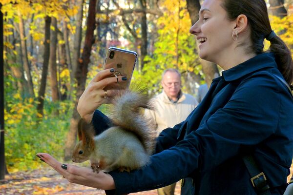 Người phụ nữ chụp ảnh với con sóc trong vườn Neskuchny ở Moskva - Sputnik Việt Nam