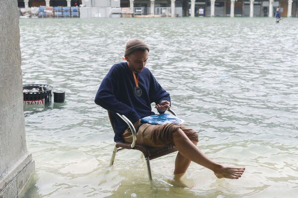 Người đàn ông ngồi trên ghế trong một trận lụt ở Venice. - Sputnik Việt Nam