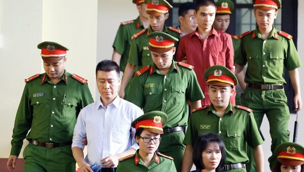 Bị cáo Phan Sào Nam (áo trắng) cùng các bị cáo được cơ quan chức năng dẫn giải ra tòa. - Sputnik Việt Nam