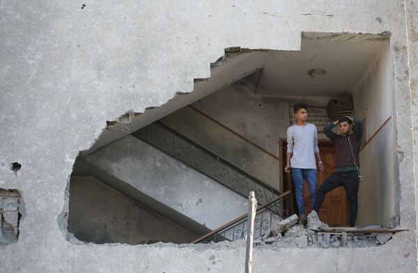 Những người thanh niên trong tòa nhà chung cư bị hư hại khi Israel tấn công vào Dải Gaza bằng tên lửa - Sputnik Việt Nam
