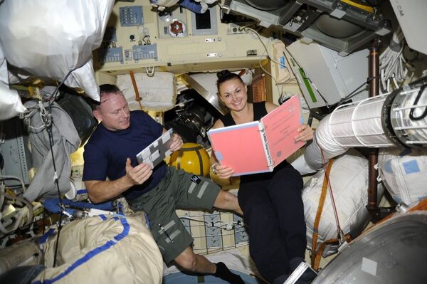 Nữ phi hành gia Nga Elena Serova lúc đọc cuốn sách hành động trong tình huống bất thường khẩn cấp EMER-1a trên khoang Trạm ISS - Sputnik Việt Nam