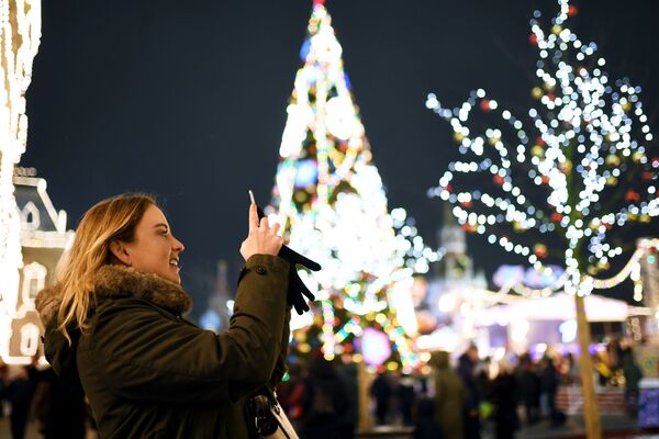 Cô gái đang chụp ảnh Quảng trường Đỏ ở Moskva được trang trí bằng đèn năm mới - Sputnik Việt Nam